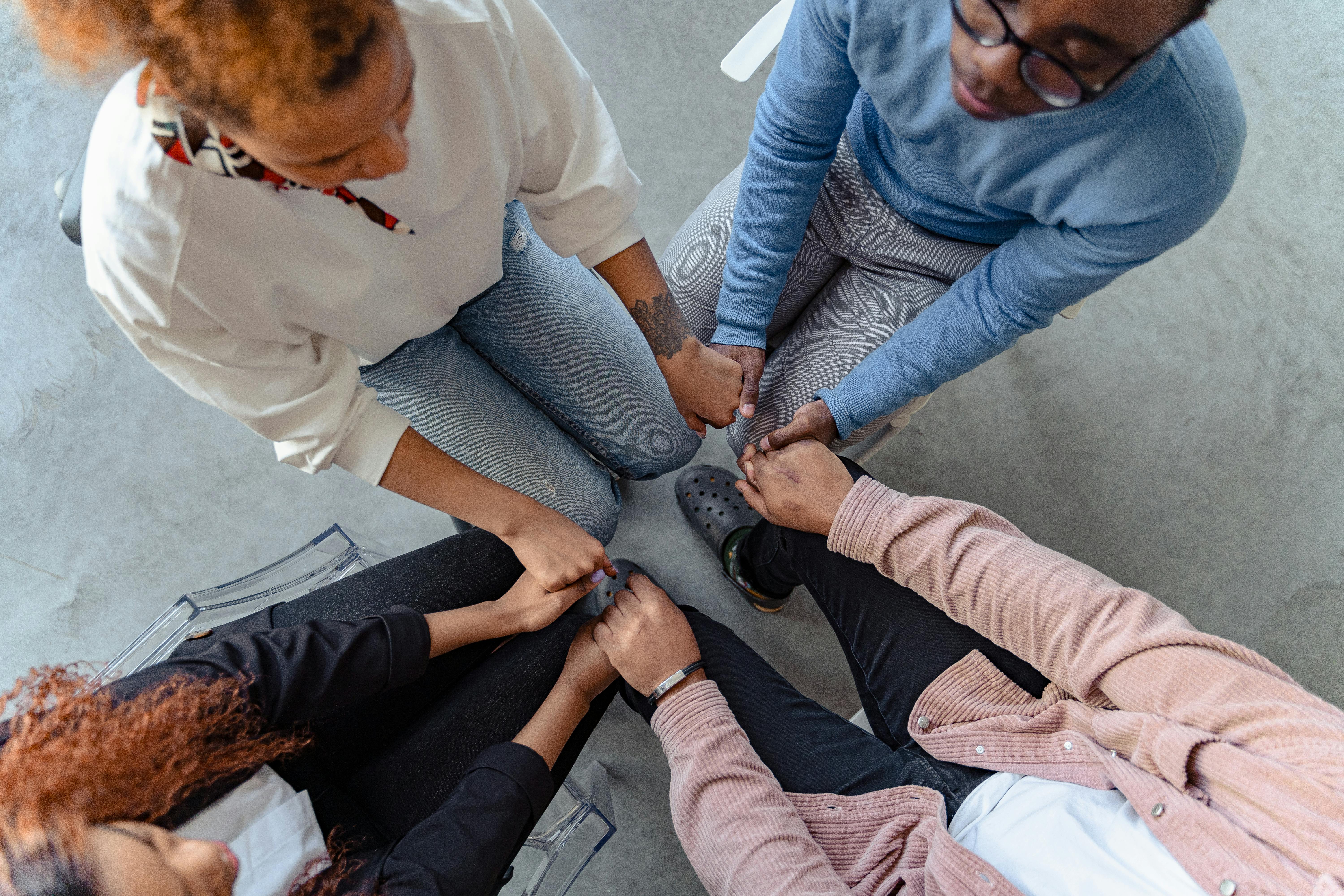 Overhead view of a group holding hands in a circle.