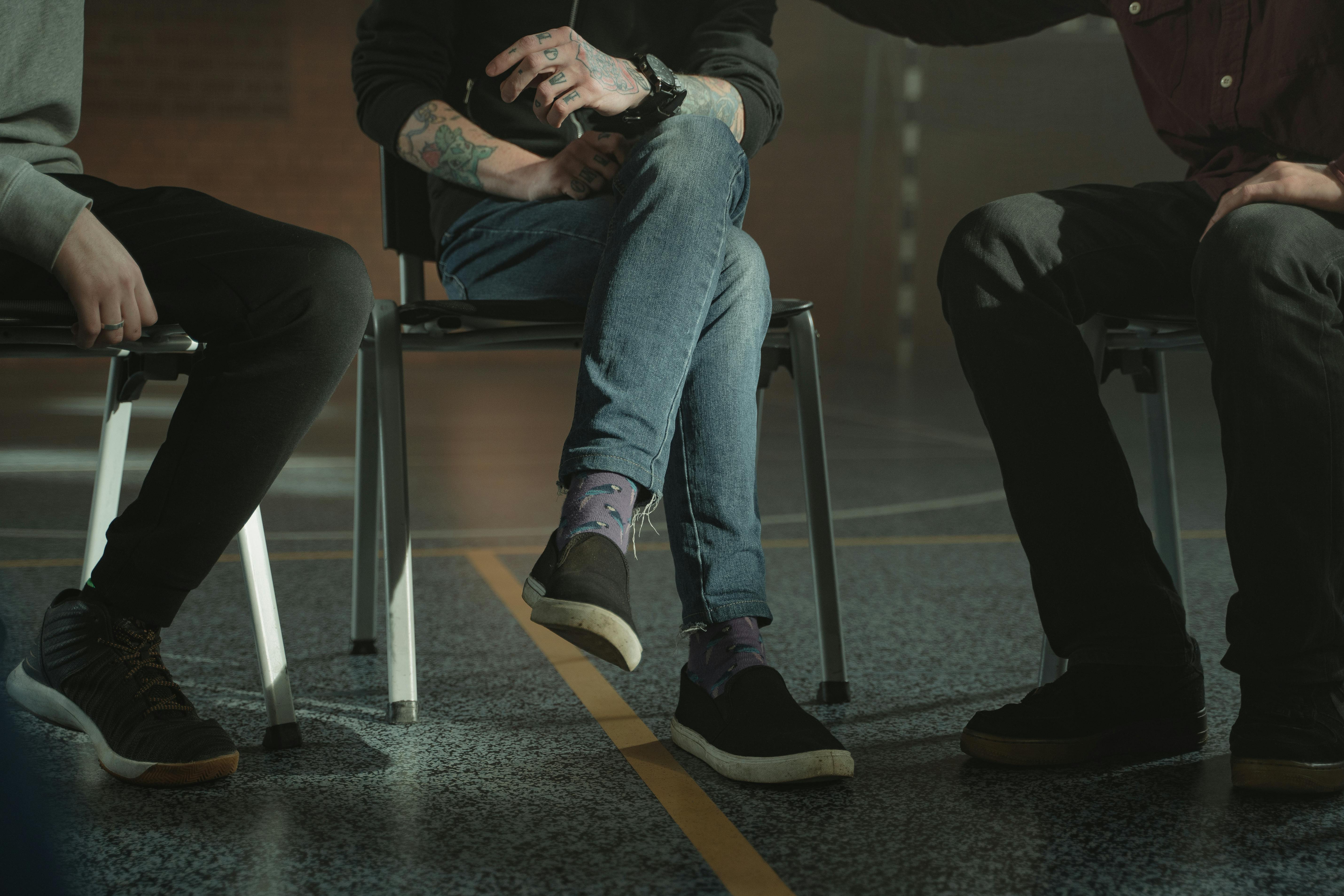 Men sitting in a group therapy session.